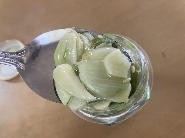 カルディの青いにんにく辣油をスプーンですくっています。