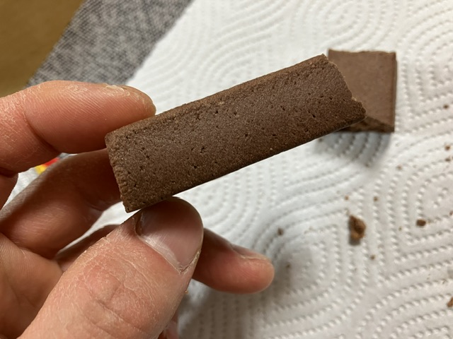 inバープロテインベイクドチョコを手に取ってます。