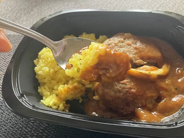 ターメリックご飯にカレーを潜らせスプーンにのせています。