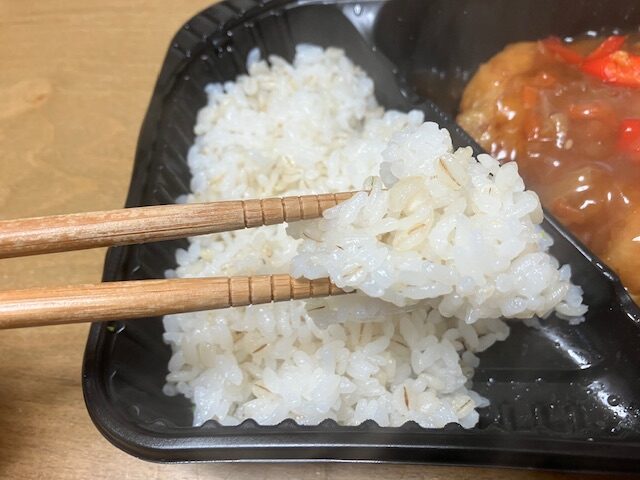 おし麦ご飯をお箸で掴んでいます。